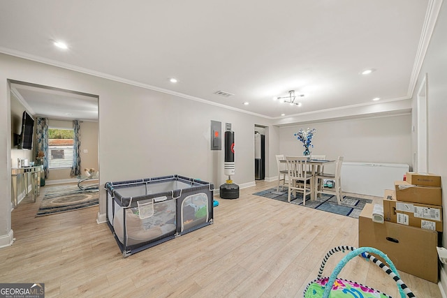 recreation room with light hardwood / wood-style flooring and crown molding