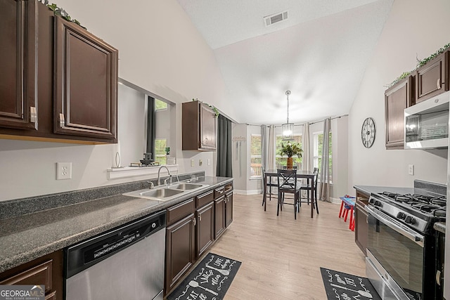 kitchen featuring dark brown cabinetry, sink, vaulted ceiling, and appliances with stainless steel finishes