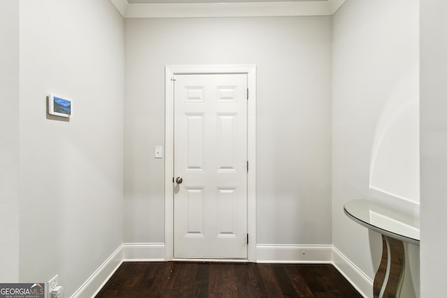 doorway featuring ornamental molding and dark wood-type flooring