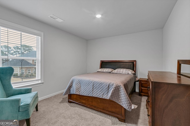 bedroom with light colored carpet and multiple windows