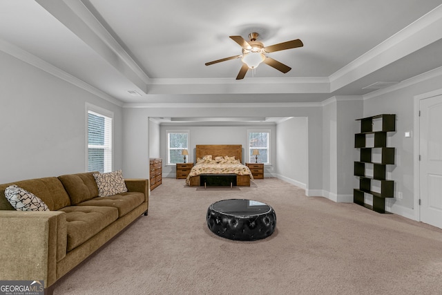 carpeted bedroom featuring ceiling fan, a raised ceiling, and crown molding