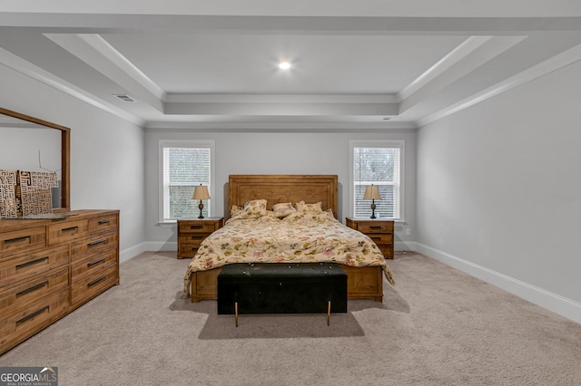 carpeted bedroom featuring a tray ceiling, multiple windows, and ornamental molding