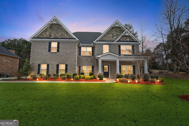 craftsman-style home featuring a lawn and central air condition unit