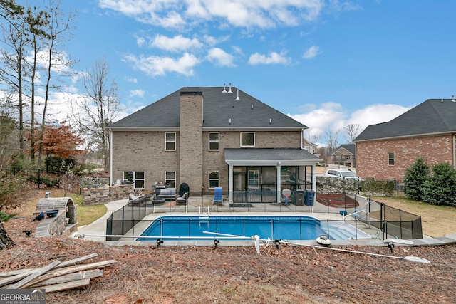 view of swimming pool featuring a sunroom and a patio