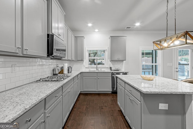 kitchen with gray cabinets, light stone countertops, stainless steel appliances, and ornamental molding