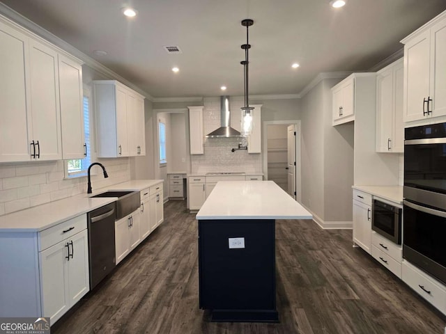 kitchen featuring wall chimney exhaust hood, sink, dishwasher, a center island, and white cabinetry