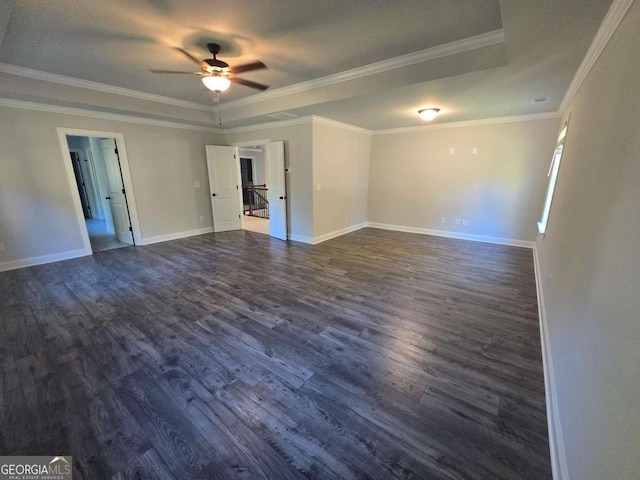 unfurnished room featuring ceiling fan, crown molding, dark wood-type flooring, and a tray ceiling