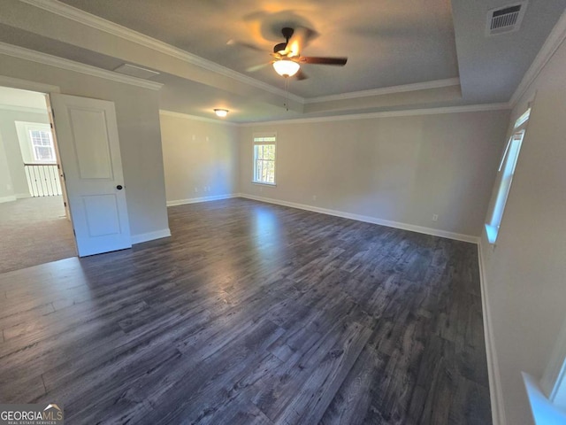 spare room featuring a tray ceiling, dark hardwood / wood-style floors, crown molding, and ceiling fan