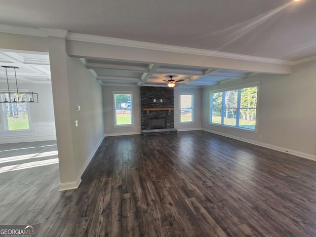 unfurnished living room featuring coffered ceiling, a stone fireplace, dark hardwood / wood-style flooring, beamed ceiling, and ornamental molding