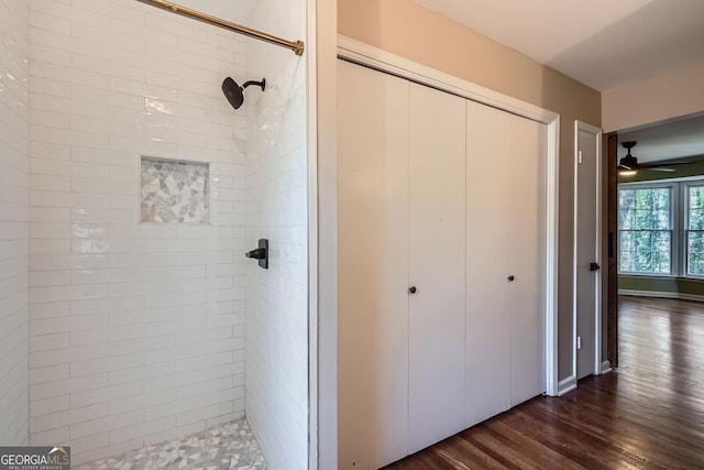 bathroom with tiled shower, hardwood / wood-style flooring, and ceiling fan