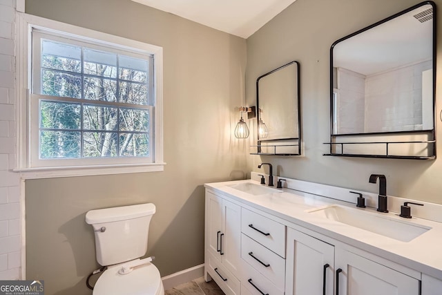 bathroom featuring vanity, toilet, and plenty of natural light