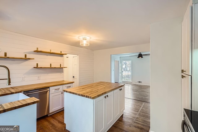 kitchen with dishwasher, a center island, wooden counters, white cabinets, and sink