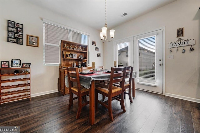 dining area featuring dark wood-type flooring and a chandelier