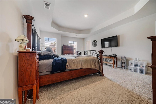 carpeted bedroom with a tray ceiling