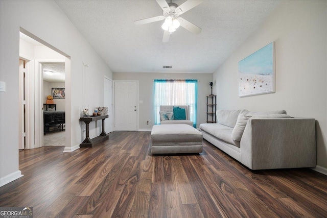 unfurnished living room featuring dark hardwood / wood-style floors, ceiling fan, and a textured ceiling