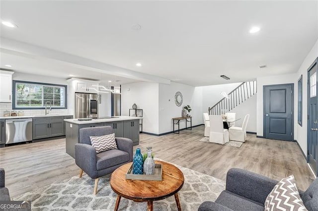 living room with sink and light wood-type flooring