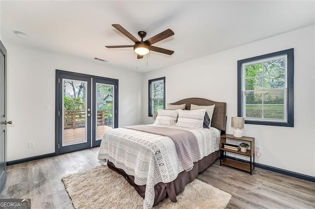 bedroom with multiple windows, access to outside, light hardwood / wood-style flooring, and ceiling fan