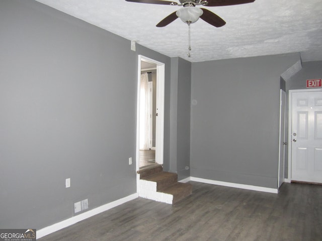 unfurnished room with dark hardwood / wood-style flooring, a textured ceiling, and ceiling fan