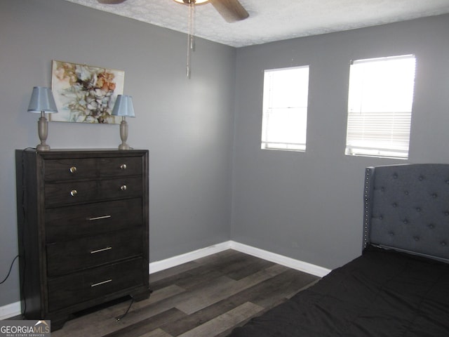 unfurnished bedroom featuring ceiling fan, dark hardwood / wood-style flooring, and a textured ceiling