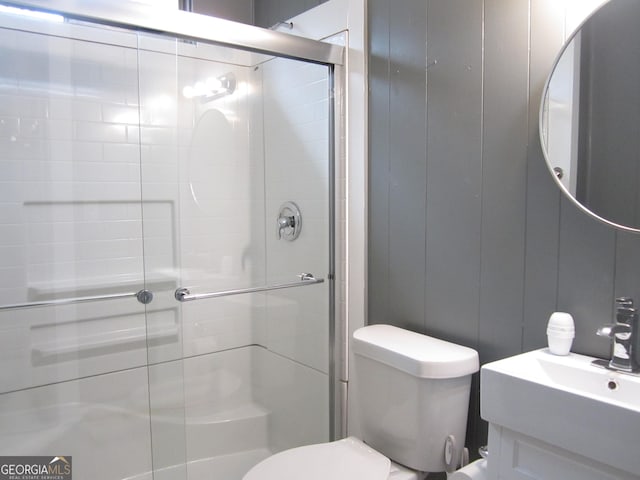 bathroom featuring toilet, vanity, and walk in shower