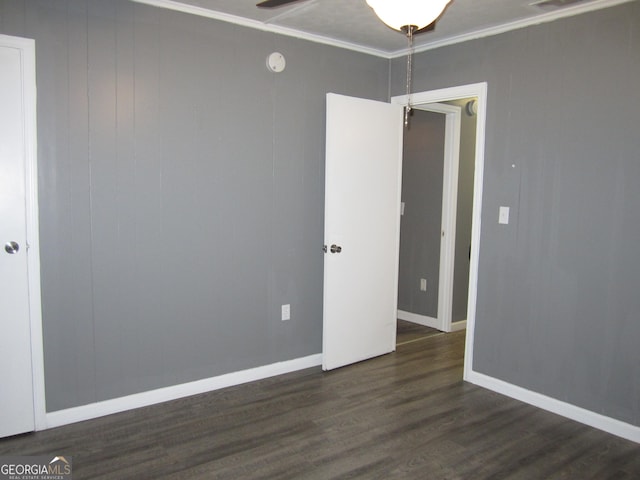 unfurnished room featuring ceiling fan, crown molding, and dark wood-type flooring