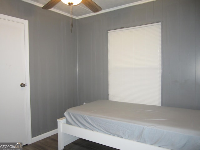 bedroom with dark hardwood / wood-style flooring, ceiling fan, and crown molding