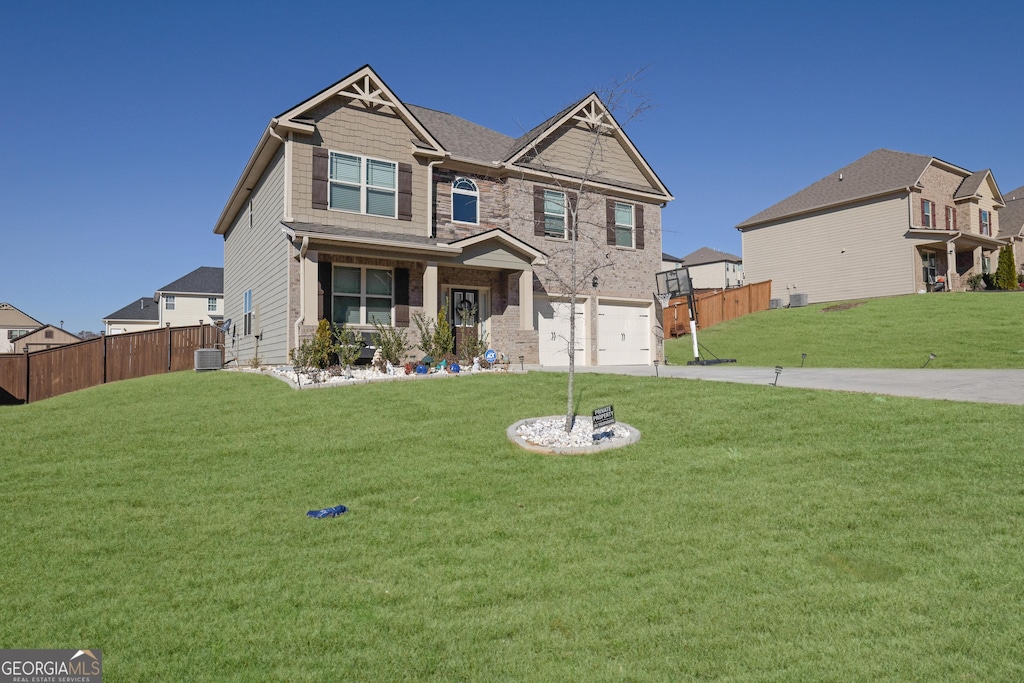 craftsman inspired home featuring central air condition unit, a front lawn, and a garage