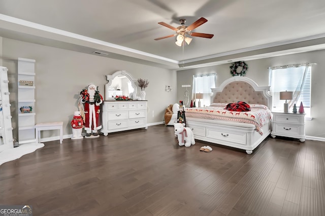 bedroom featuring ceiling fan, dark hardwood / wood-style flooring, a raised ceiling, and multiple windows