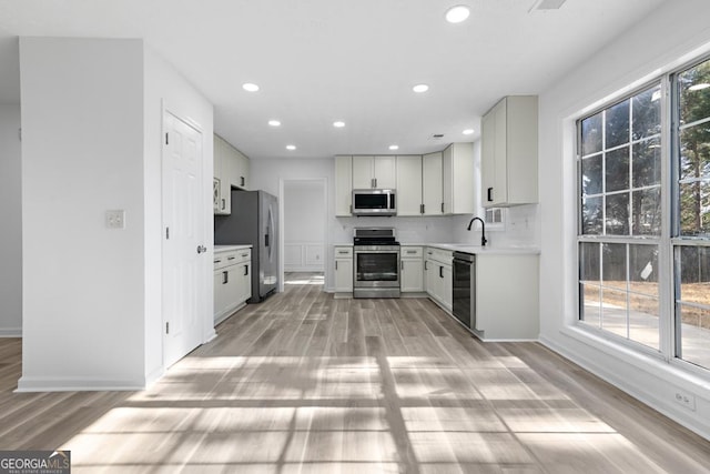 kitchen featuring plenty of natural light, white cabinetry, and stainless steel appliances