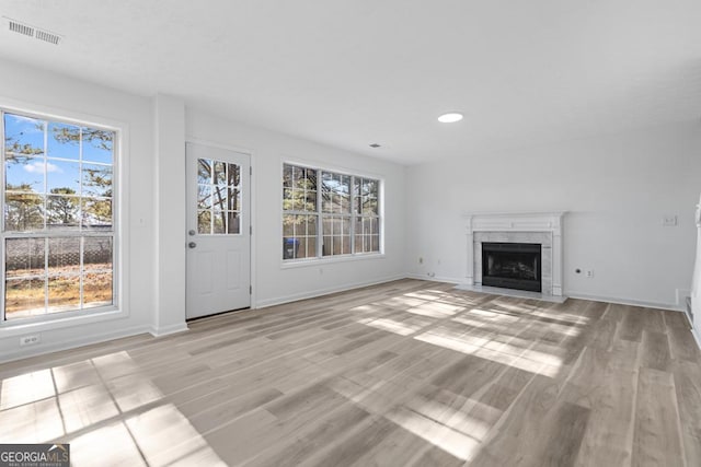 unfurnished living room with light hardwood / wood-style flooring and a premium fireplace