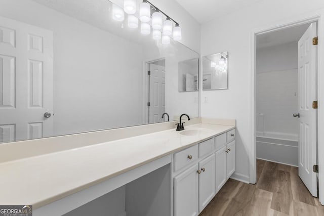 bathroom featuring vanity, wood-type flooring, and bathing tub / shower combination