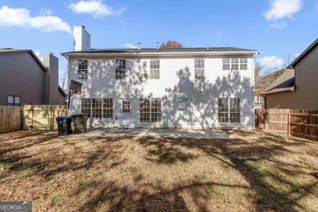 back of house with a yard and a patio