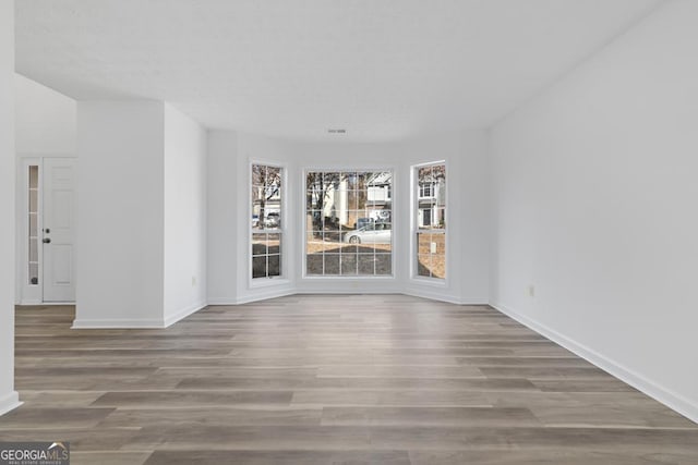 unfurnished room with wood-type flooring