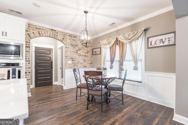 dining room with a wainscoted wall, visible vents, arched walkways, and dark wood-type flooring