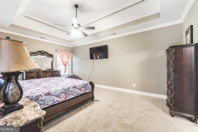 bedroom featuring ornamental molding, a tray ceiling, light carpet, and baseboards