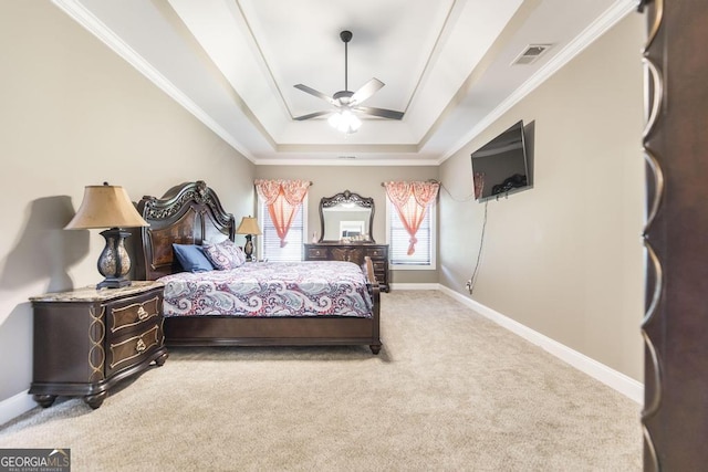 bedroom with a tray ceiling, visible vents, light carpet, and baseboards