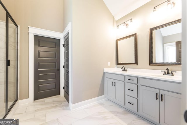 bathroom with marble finish floor, lofted ceiling, a sink, a shower stall, and baseboards