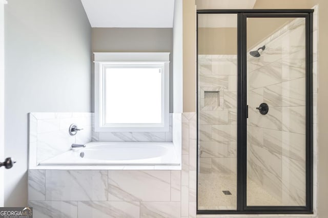 bathroom featuring a garden tub and a shower stall