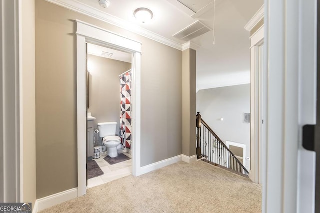 hallway with ornamental molding, an upstairs landing, attic access, and light colored carpet