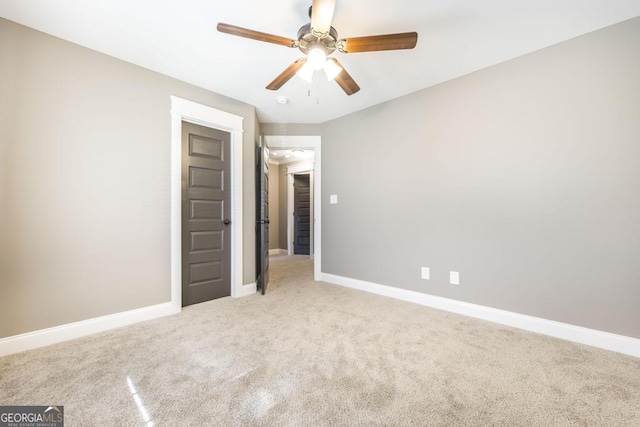 unfurnished bedroom featuring light carpet, baseboards, and a ceiling fan