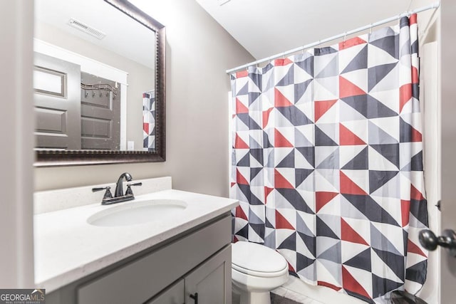 full bath with toilet, vanity, and visible vents