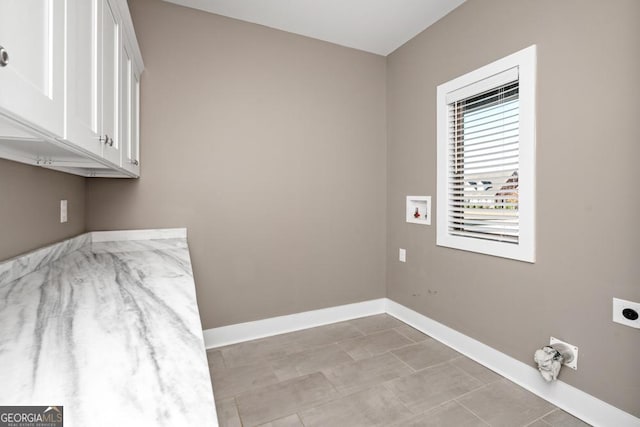 clothes washing area featuring hookup for an electric dryer, hookup for a washing machine, light tile patterned floors, and cabinets