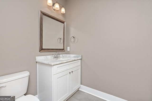 bathroom with tile patterned flooring, vanity, and toilet