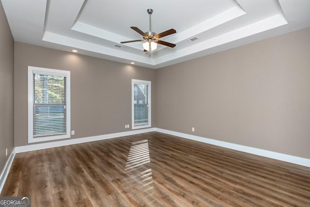 spare room featuring a tray ceiling, ceiling fan, and hardwood / wood-style flooring