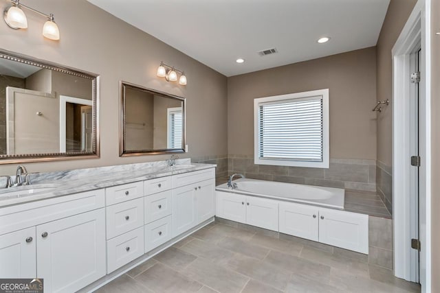 bathroom featuring tile patterned flooring, a bathtub, and vanity