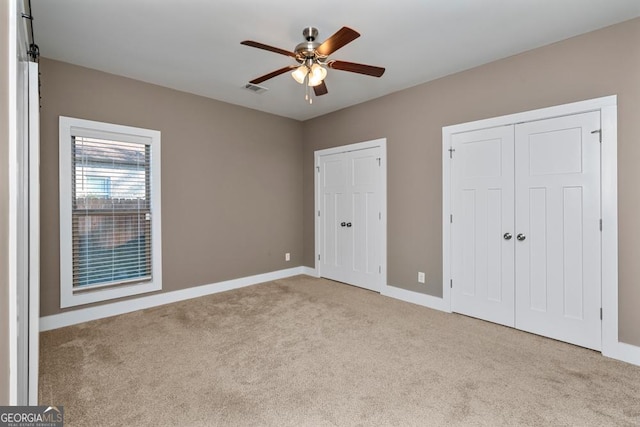 unfurnished bedroom with ceiling fan and light colored carpet