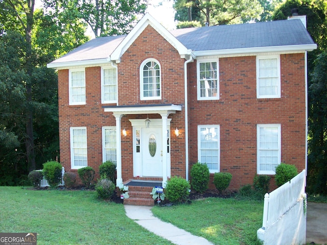 colonial inspired home featuring a front lawn