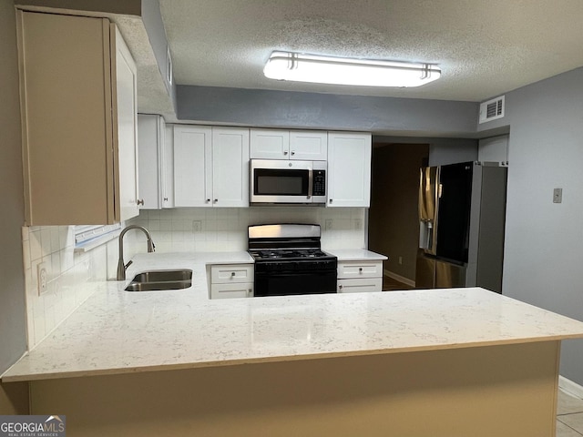 kitchen featuring backsplash, sink, kitchen peninsula, white cabinetry, and stainless steel appliances