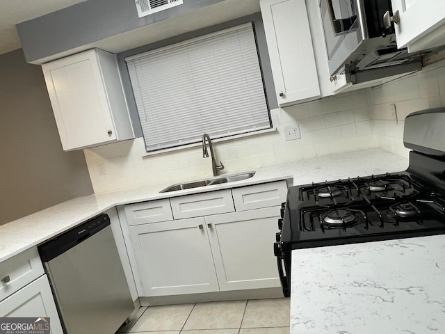 kitchen featuring gas stove, white cabinetry, stainless steel dishwasher, and sink