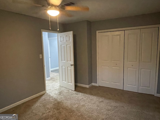 unfurnished bedroom featuring carpet flooring, ceiling fan, and a closet